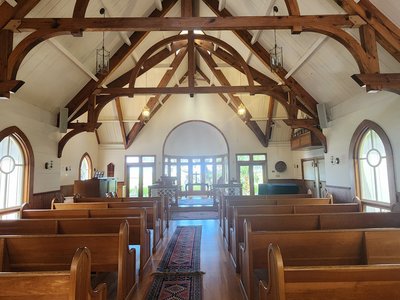 Timber-frame vaulted wooden beams and pews inside the historic island chapel.
