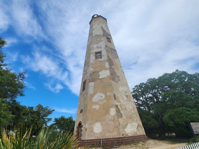 ow-angle shot of historic Old Baldy Lighthouse standing tall above the maritime forest.