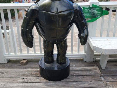 Standing sea turtle sculpture and educational nesting guidelines sign along the nature center deck.