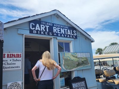 Blue rental shack and lineup of golf carts ready for island day-trippers.