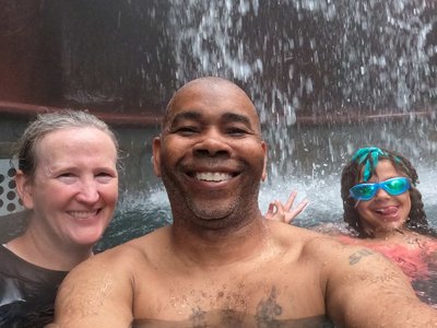 Soaking under the heavy mineral waterfall cascade inside one of the main heated pools at Baldi.