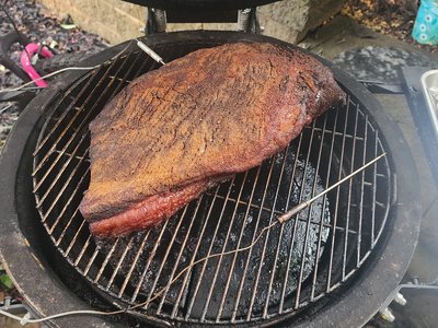 Mid-cook progress check showing mahogany bark and fat cap rendering.