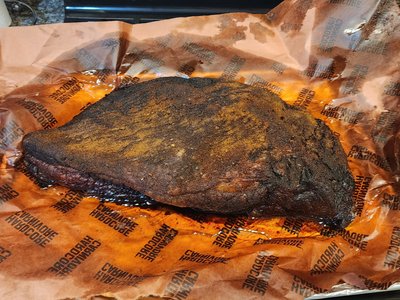 Whole cooked brisket resting on Hardcore Carnivore pink butcher paper before slicing.