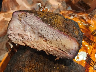Sliced cross-section showcasing smoke ring definition and rendered fat layer.